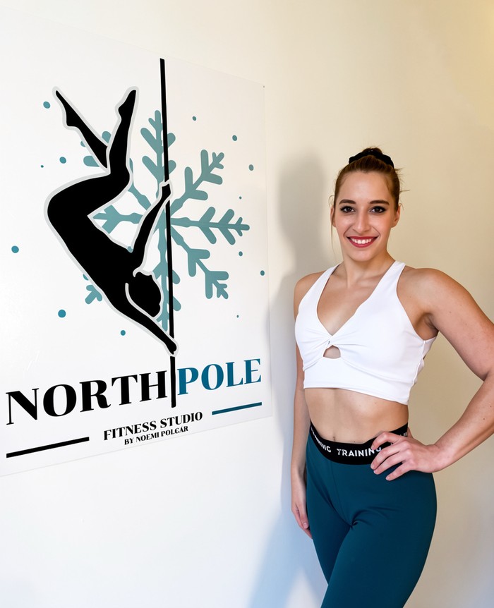 Polgár Noémi, rúdtánc és rúdfitness edző a North Pole Fitness logója mellett, 7. kerület